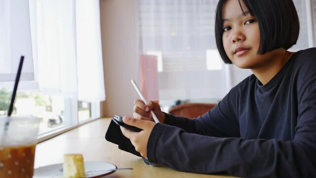 Asian teenager to use tablet drawing and ding homework in living room