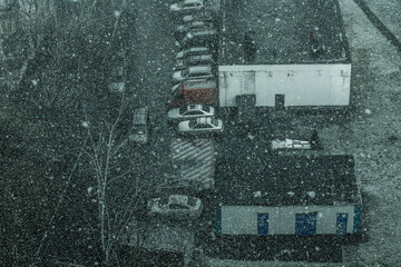 Cars in the yard during the snowfall in Moscow