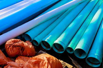 Large blue industrial PVC sewer pipes road construction with barricades