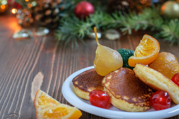 Traditional fluffy japanese pancakes with spanish glazed fruits on the Christmas table. Delicious festive breakfast, healthy eating.
