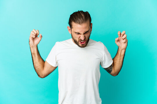Young man with long hair look screaming with rage.