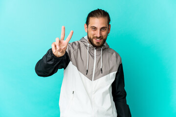 Fototapeta premium Young man with long hair look joyful and carefree showing a peace symbol with fingers.