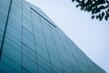 Fototapeta na wymiar High-rise building made of dark glass against a clear blue sky, background