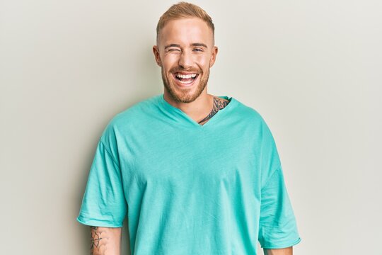 Young caucasian man wearing casual clothes winking looking at the camera with sexy expression, cheerful and happy face.