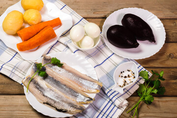 Ingridients for russian salad. Potatoes, carrots, herring, eggs placed on the table. Ready for cooking.