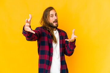 Young man with long hair look feels confident giving a hug to the camera.