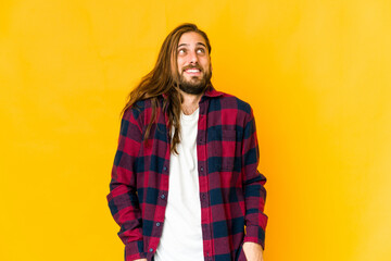 Young man with long hair look laughs and closes eyes, feels relaxed and happy.