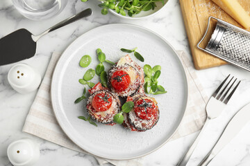 Baked eggplant with tomatoes, cheese and basil served on white marble table, flat lay