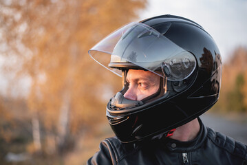 Biker in the helmet with open visor close up portrait.