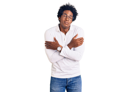 Handsome african american man with afro hair wearing casual clothes and glasses shaking and freezing for winter cold with sad and shock expression on face