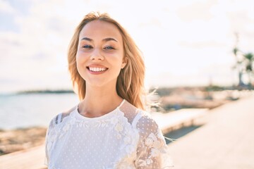 Young caucasian girl smiling happy walking at the promenade.