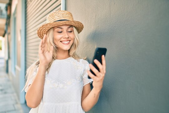 Young caucasian tourist girl doing video call using smartphone at city.