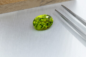 macro mineral faceted stone cut Peridot on a gray background