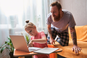 Man standing on his knees near his blonde daughter