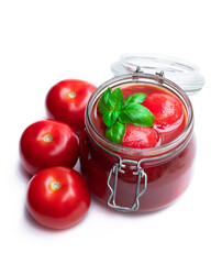 Homemade peeled tomatoes in tomato juice in glass jar isolated on white