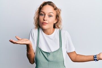 Beautiful caucasian woman wearing casual clothes clueless and confused expression with arms and...