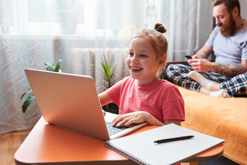 Kid using laptop at home at self isolation