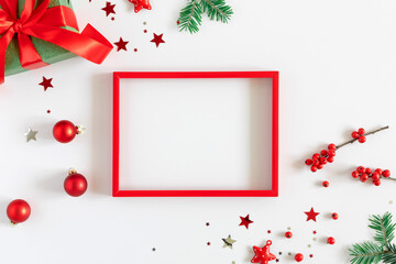 Christmas holiday composition. Red photo frame, Xmas decorations on white background. Christmas, New Year, winter concept. Flat lay, top view, copy space