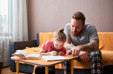 Girl studying at home with her daddy