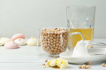 Whipped to a foam aquafaba for making meringue, chickpeas and prepared sweets. Close-up on a light background