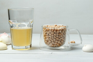 Chickpea grains in a glass Cup and aquafaba, the liquid obtained after decocting chickpeas or...
