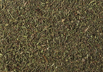 Dry chopped summer savory (Satureja hortensis) background and texture, top view