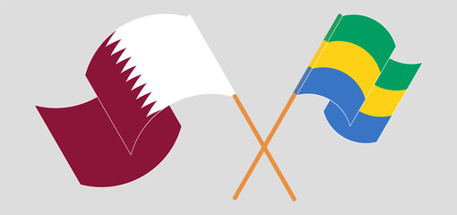 Crossed and waving flags of Qatar and Gabon
