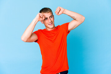 Naklejka premium Young caucasian handsome man celebrating a special day, jumps and raise arms with energy.