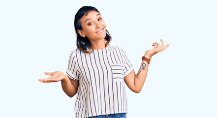 Young woman wearing casual clothes clueless and confused expression with arms and hands raised....