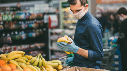 customer in protective gloves choosing bananas in a supermarket