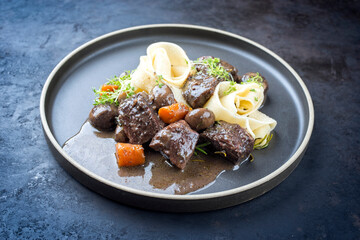 Modern style traditional French boeuf bourguignon with tagliatelle noodles in red wine sauce served...
