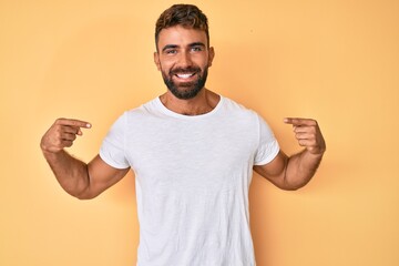 Young hispanic man wearing casual clothes looking confident with smile on face, pointing oneself...