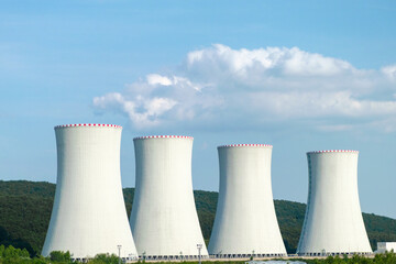 Nuclear power plant. Cooling towers on the background of blue sky and mountains