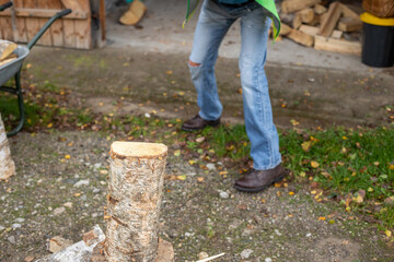 Man holding the heavy axe. Axe in lumberjack hands chopping or cutting wood trunks. Wood chips fly apart.