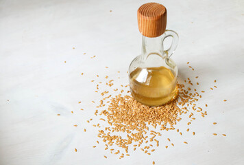 Flax seed oil in a glass bottle with seeds spread around.