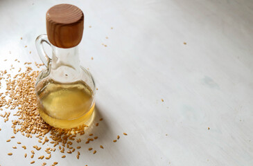 Flax seed oil in a glass bottle with seeds spread around.