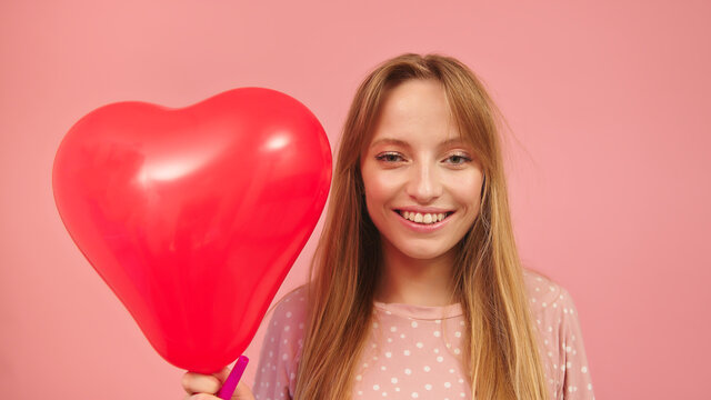  Valentines day, love and romance concept . Portrait of young woman holdingheart balloon. High quality photo