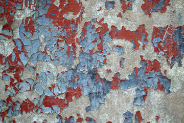Close-up weathered wall with chipped blue and red paint. Old colored concrete wall. cracked texture, abstract background.