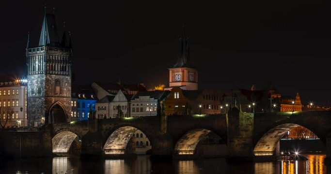 time lapse of the old stone Charles bridge and lights from street lights and the flowing Vltava river in the center of Prague in the Czech Republic at night