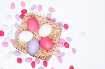 Easter eggs in the nest on white wooden background