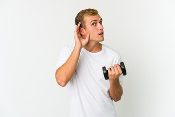 Young caucasian man holding a weight isolated on white background