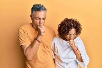 Beautiful middle age couple together wearing casual clothes feeling unwell and coughing as symptom for cold or bronchitis. health care concept.