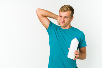 Young caucasian man drinking milk isolated on white background