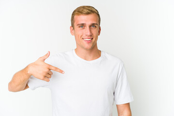 Young caucasian handsome man person pointing by hand to a shirt copy space, proud and confident