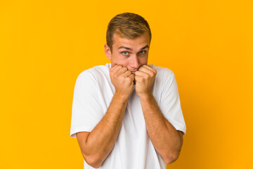 Young caucasian handsome man biting fingernails, nervous and very anxious.