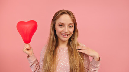 Obraz na płótnie Canvas Portrait of young woman holding heart balloon. Valentines day, love and romance concept. High quality photo