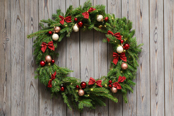 Beautiful Christmas wreath with festive decor on wooden background, top view