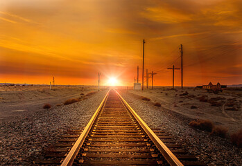 Obraz na płótnie Canvas Straight railroad heading west towards the sunset somewhere in Utah