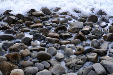 Some black stones on the shore.