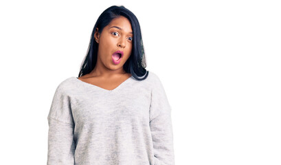 Fototapeta premium Hispanic woman with long hair wearing casual clothes in shock face, looking skeptical and sarcastic, surprised with open mouth